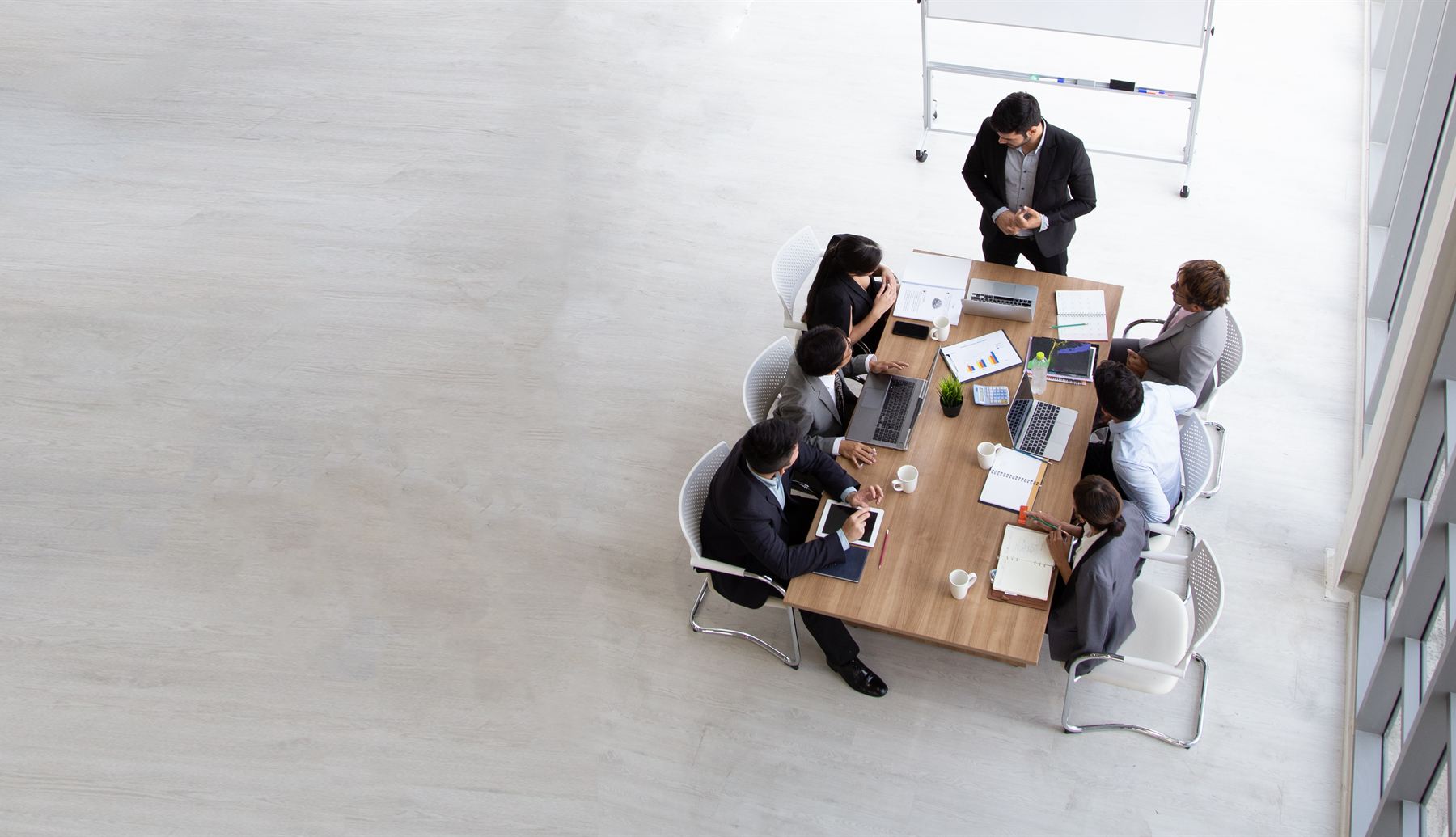 Business team meeting around a conference table, seen from above