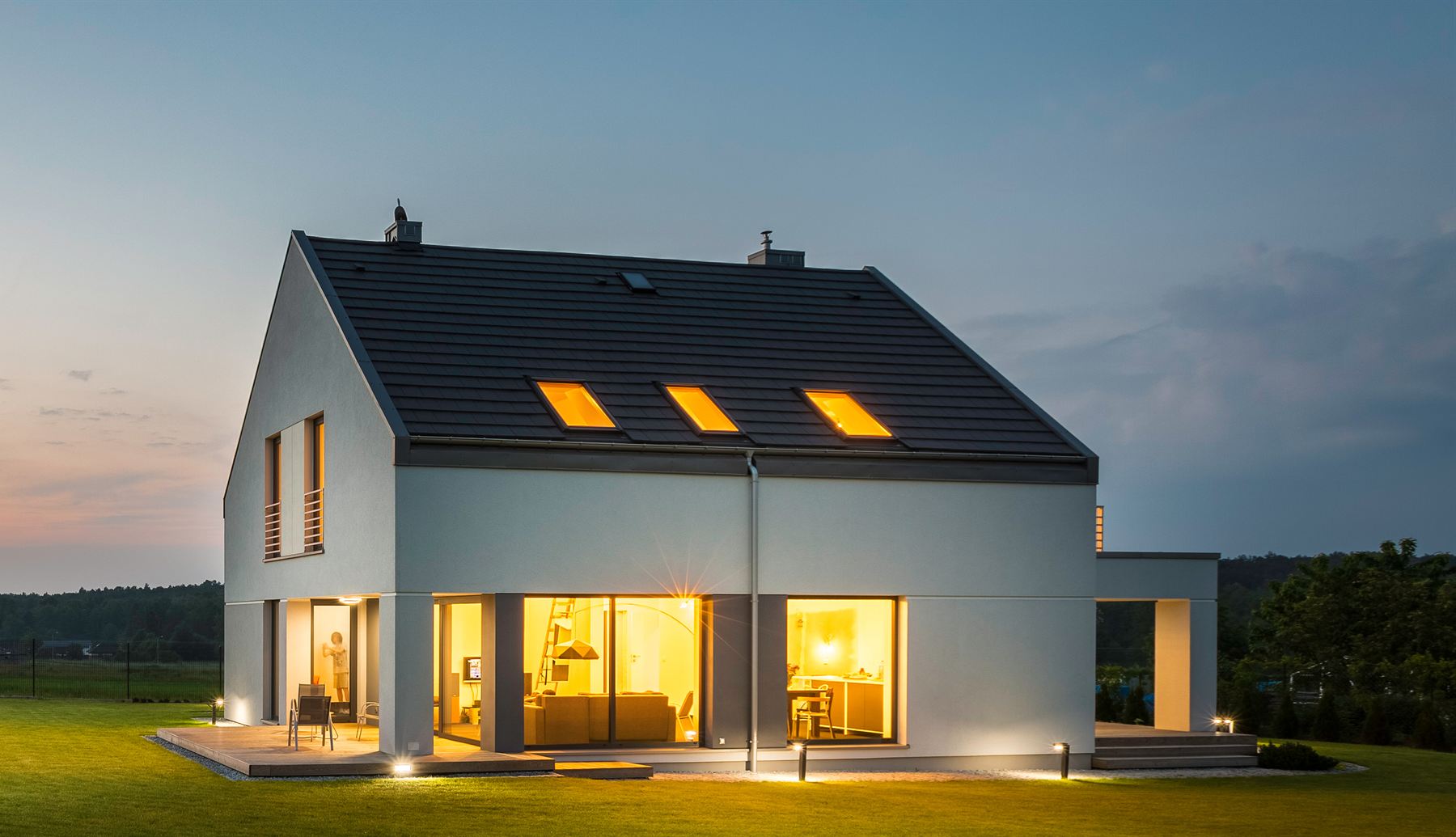 Modern home with lit windows at dusk