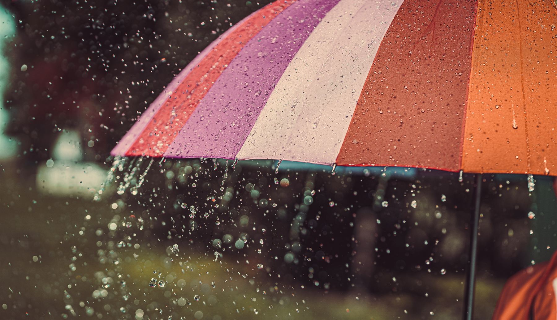 Rain pouring off a colorful umbrella